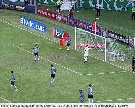 Rafael Sóbis, jogador do Fluminense, comemorando seu gol chuta a placa de propaganda e tem seu pé preso