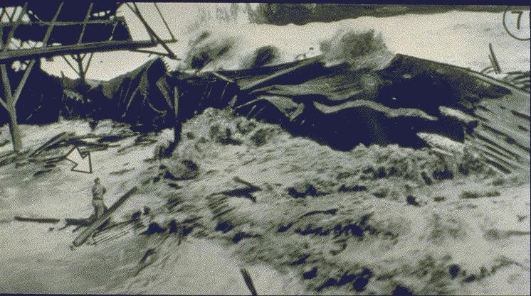 Tsunami passando sobre o Pier No. 1, Hilo Harbor. O homem indicado pela seta não sobreviveu. Foto feita pelo SS Brigham Victory, que estava atracado no momento do evento. Em 1946.